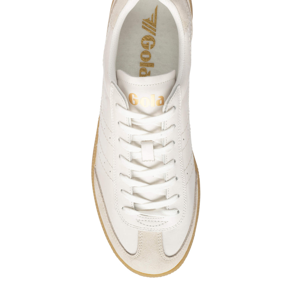 Top-down view of a white Gola trainer with gold branding and a light brown sole